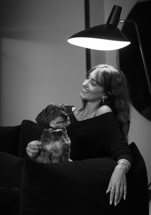 Dame sitzt auf dem Sofa mit ihrem Hund