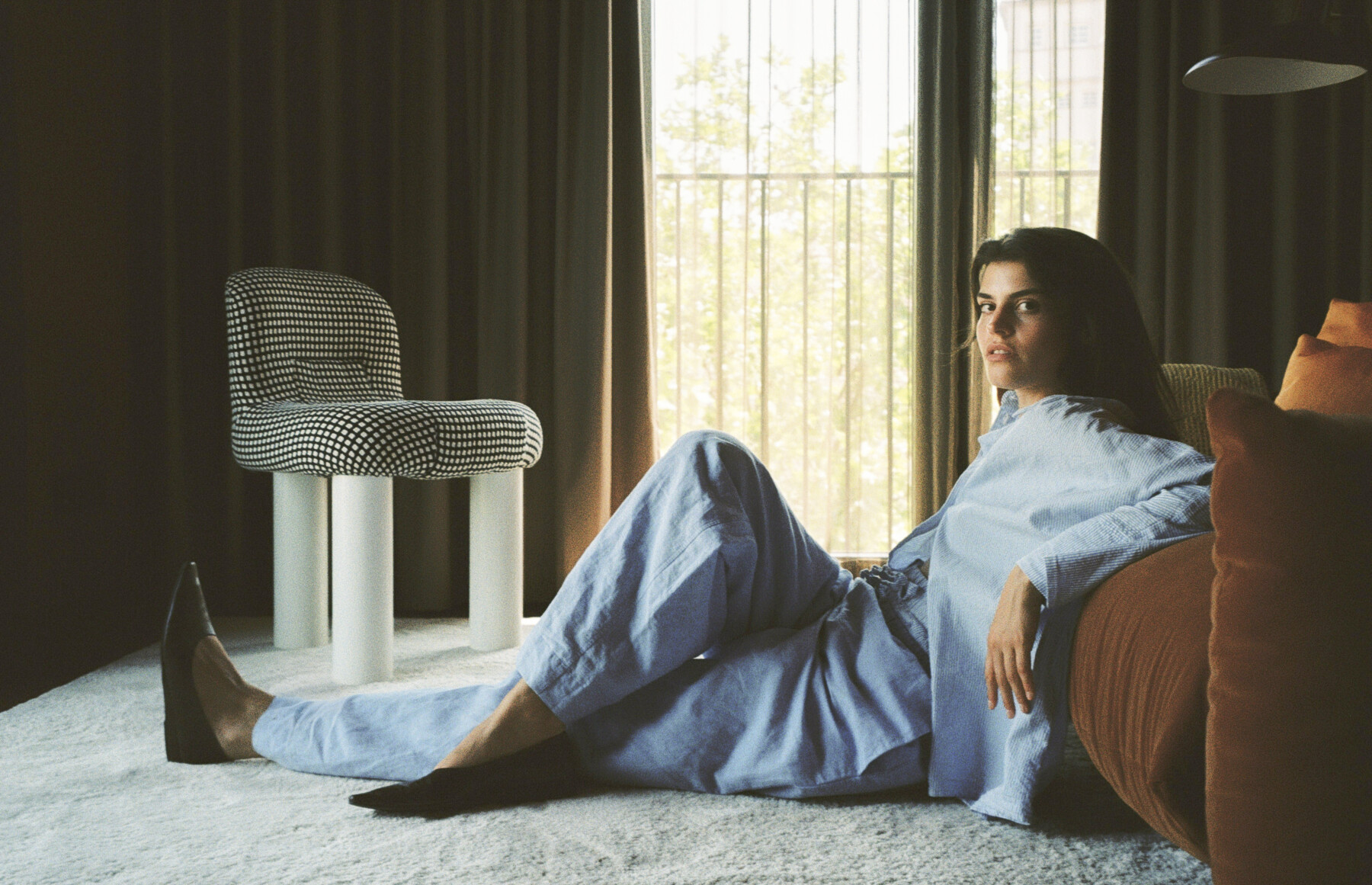 Women in blue pyjamas leaning on a red couch