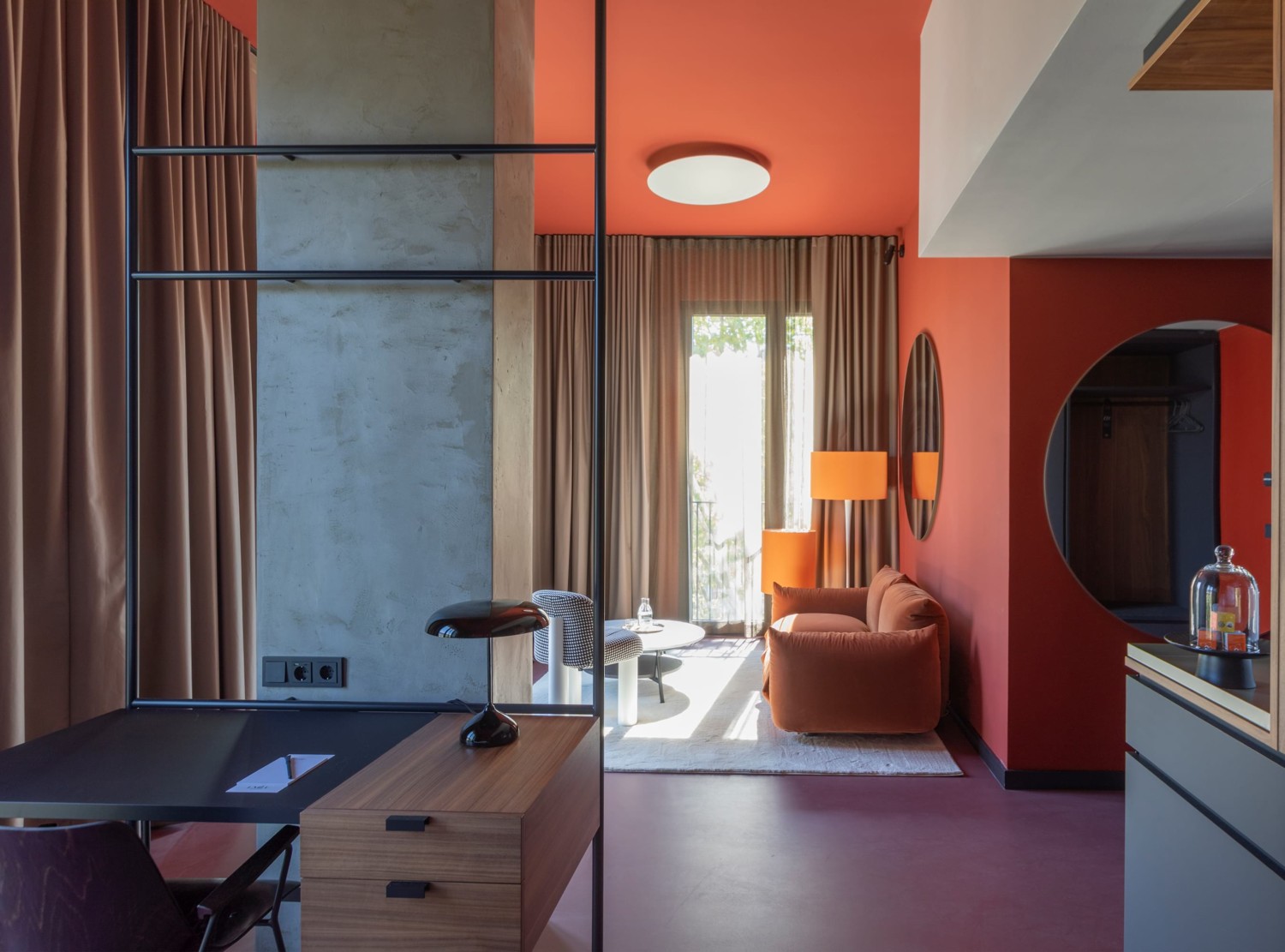 Stilvolles Hotelzimmer mit Sitz- und Arbeitsbereich in Orangetönen