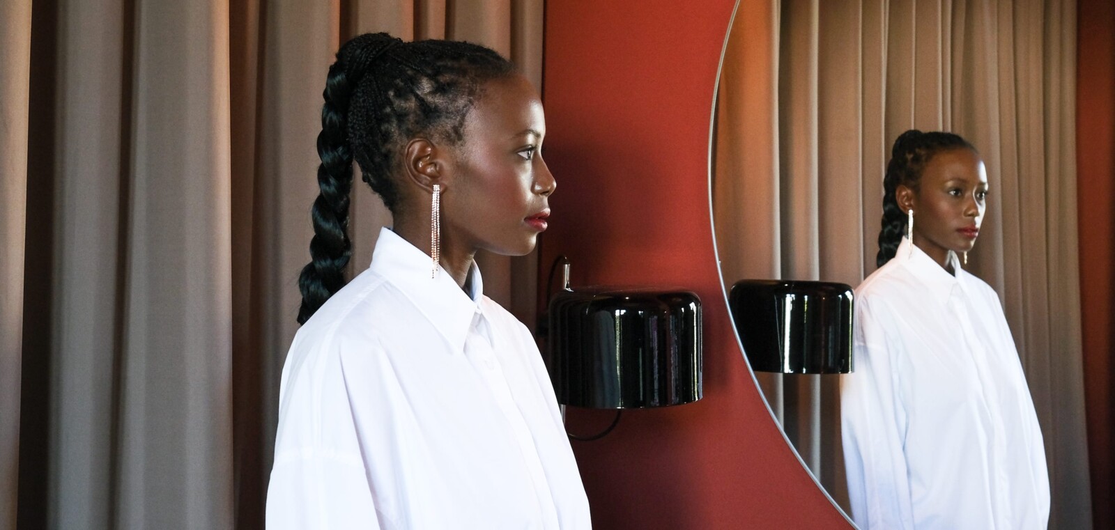 Close up of a women in a white blouse facing a mirror