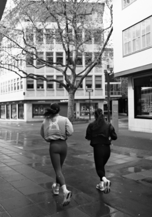 Schwarz-wei&szlig; Bild von zwei Damen welche durch die Innenstadt joggen